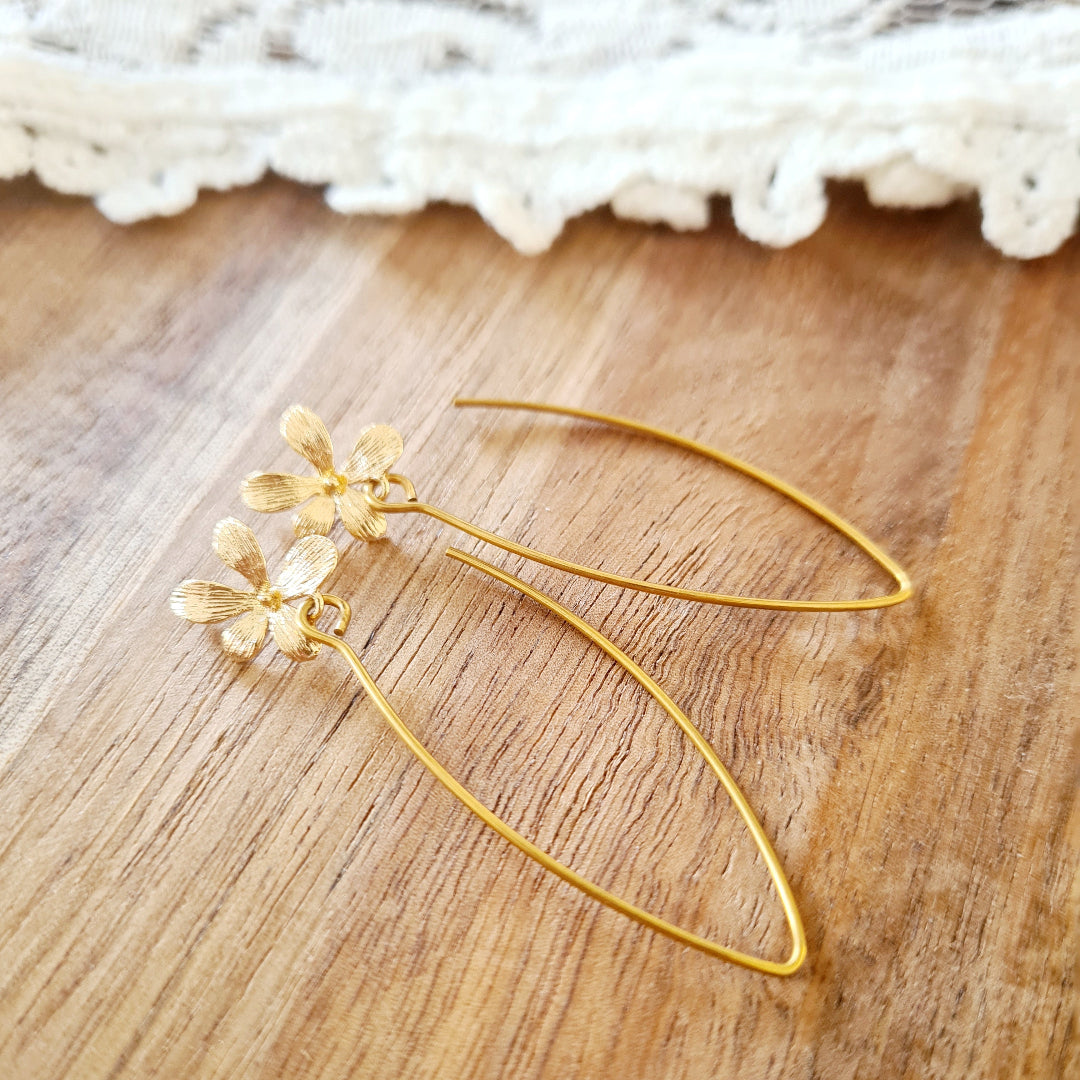 Detail gouden oorbellen met bloemhanger, stainless steel, circa 5,2 cm lang