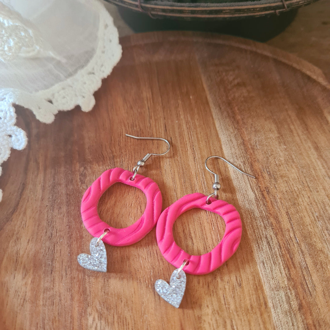 Handgemaakte roze polymeerklei oorbellen met zilverglitter hartjesbedel