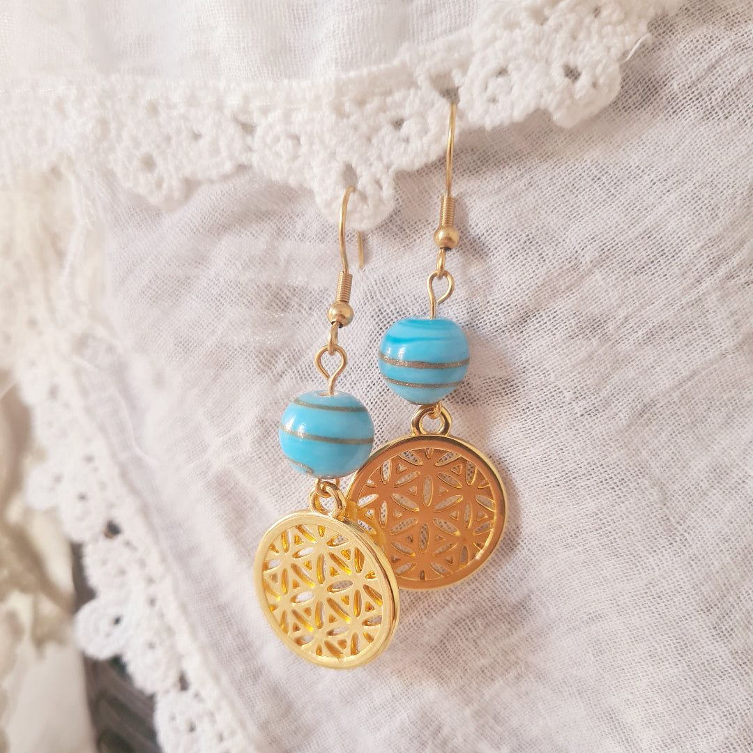 Goudkleurige oorbellen met blauwe glaskralen uit India van Little Suzies