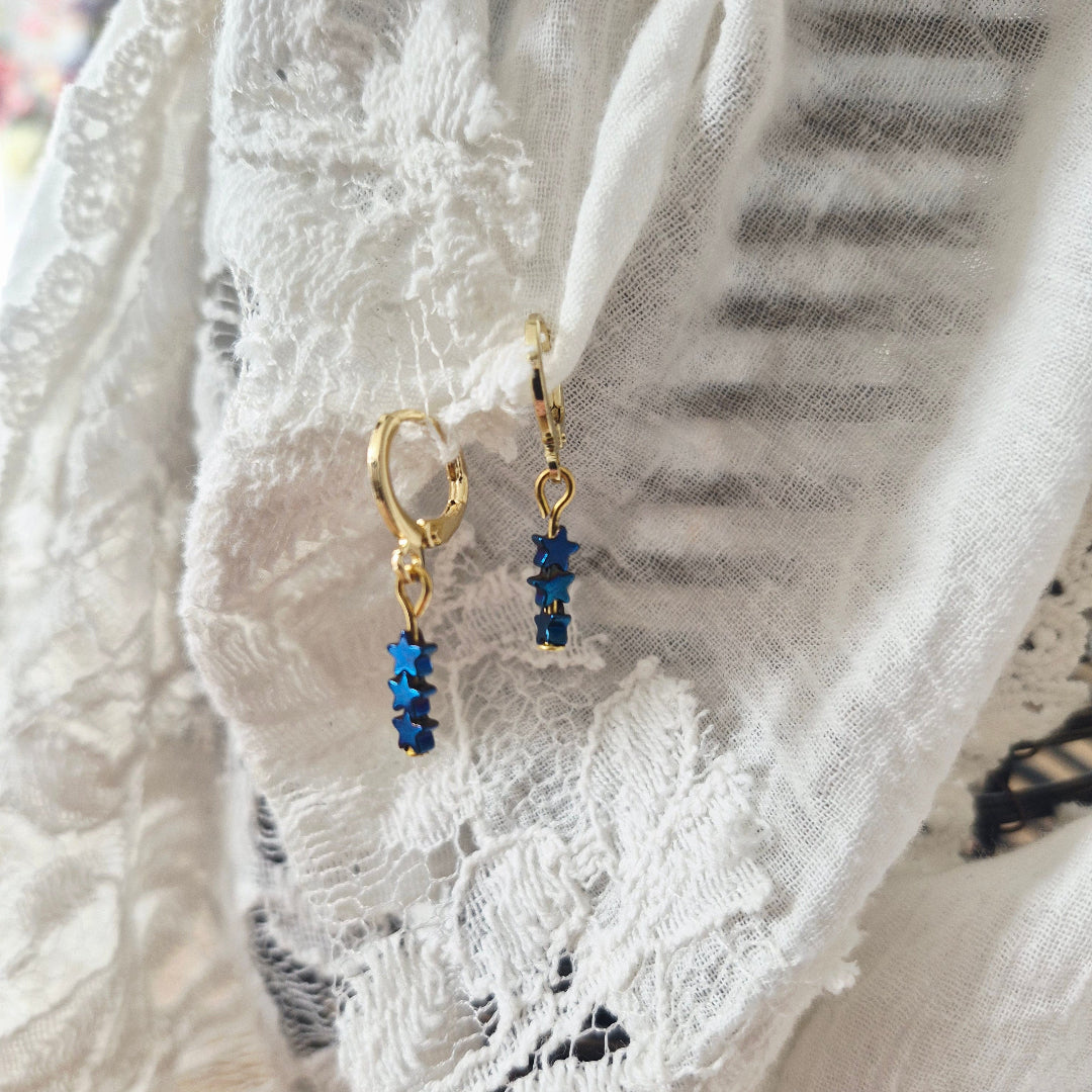 ringetjes met blauwe hematiet sterretjes in goud en zilver, close up