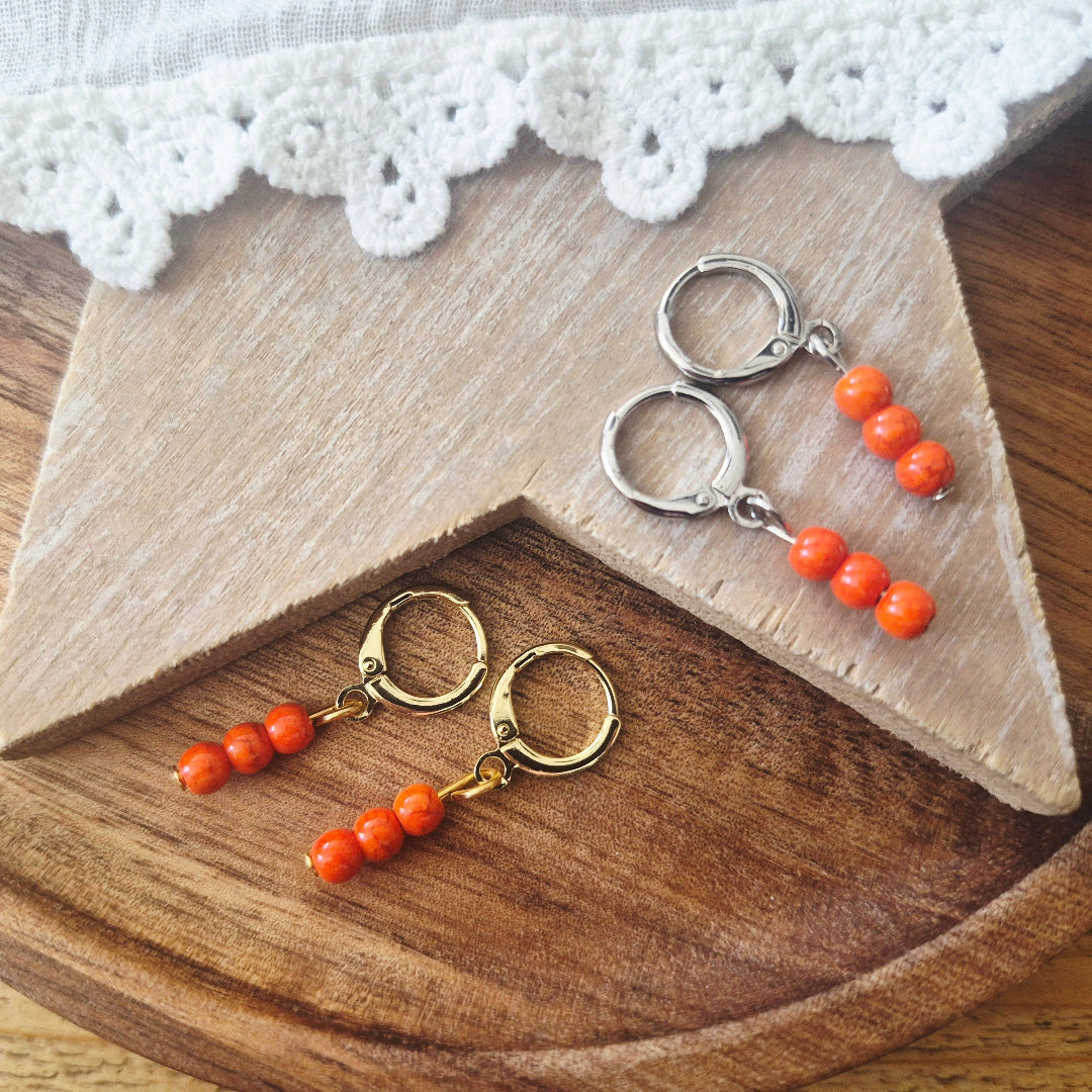 Gouden of zilveren ringetjes met oranje rocaille kraaltjes
