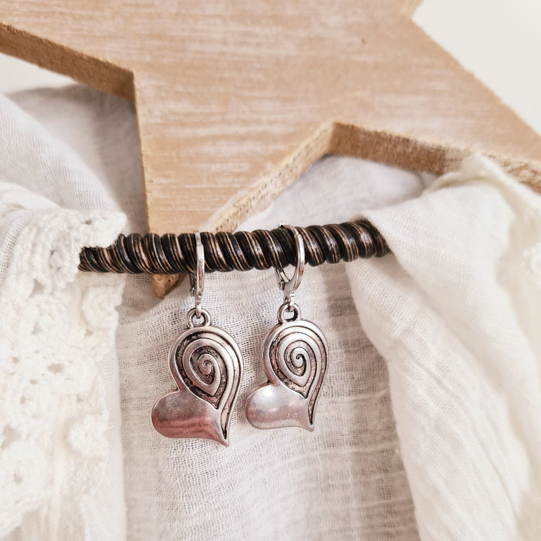 Zilveren ringetjes met hartjesbedel en spiraal detail, elegante minimalistische oorbellen met hartje