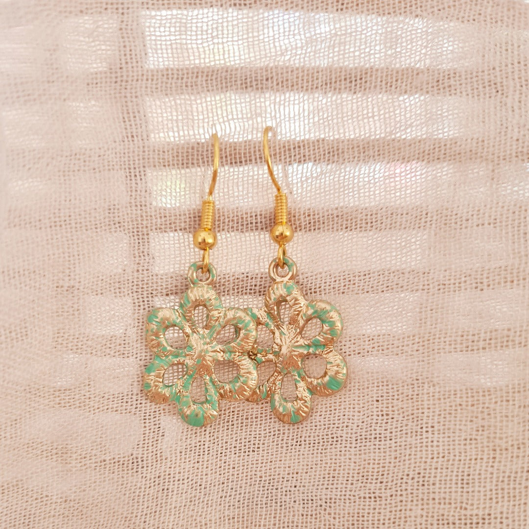 Detailfoto goudkleurige oorbellen met geoxideerde bloem en turquoise vintage glans, nikkelvrij