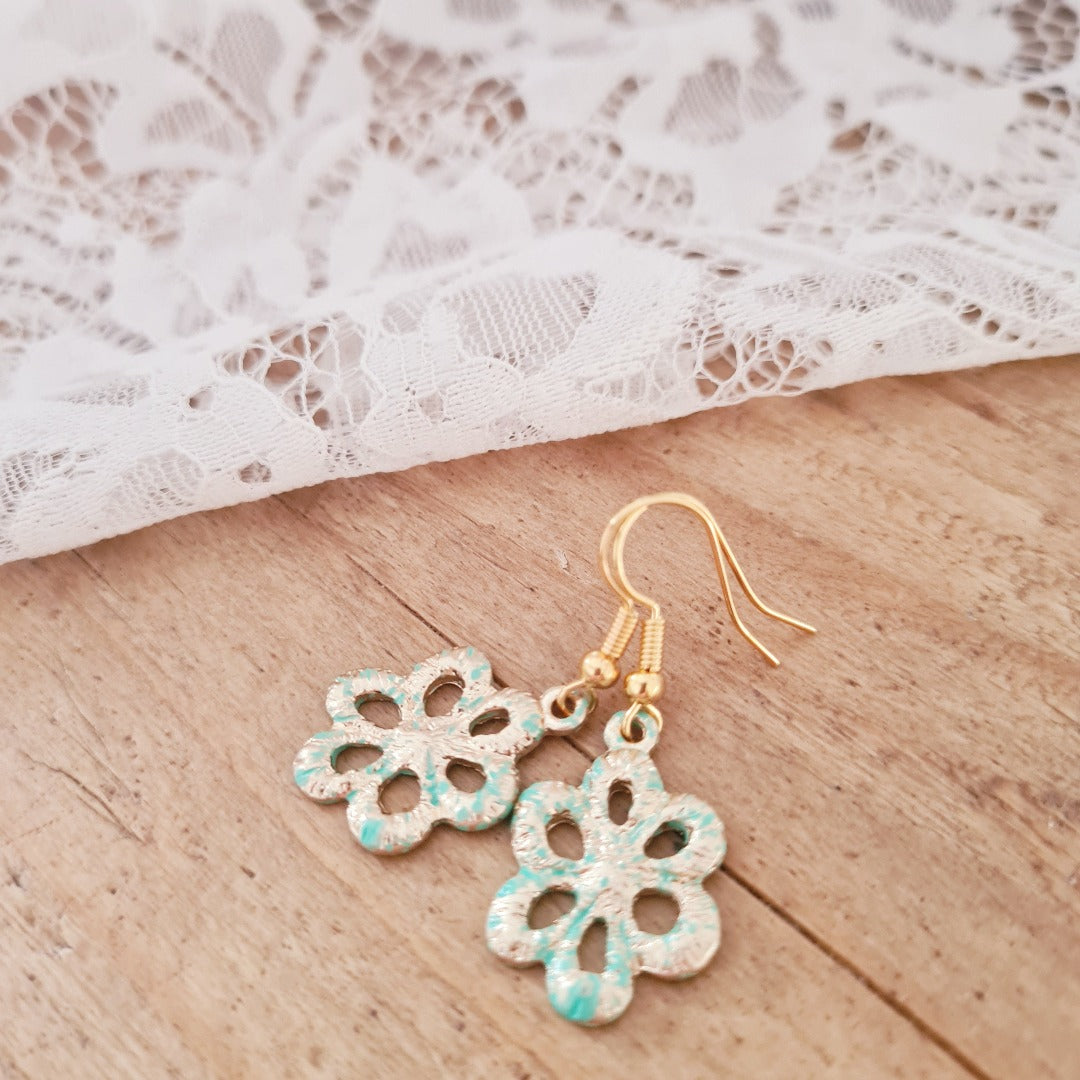 Goudkleurige oorbellen met geoxideerde bloemvormige bedel en turquoise glans, nikkelvrij