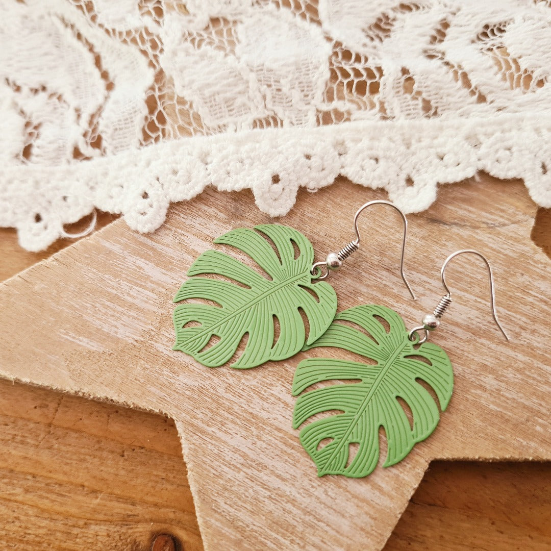 Detailfoto zilveren oorbellen met groene bladbedel, speels natuurlijk ontwerp