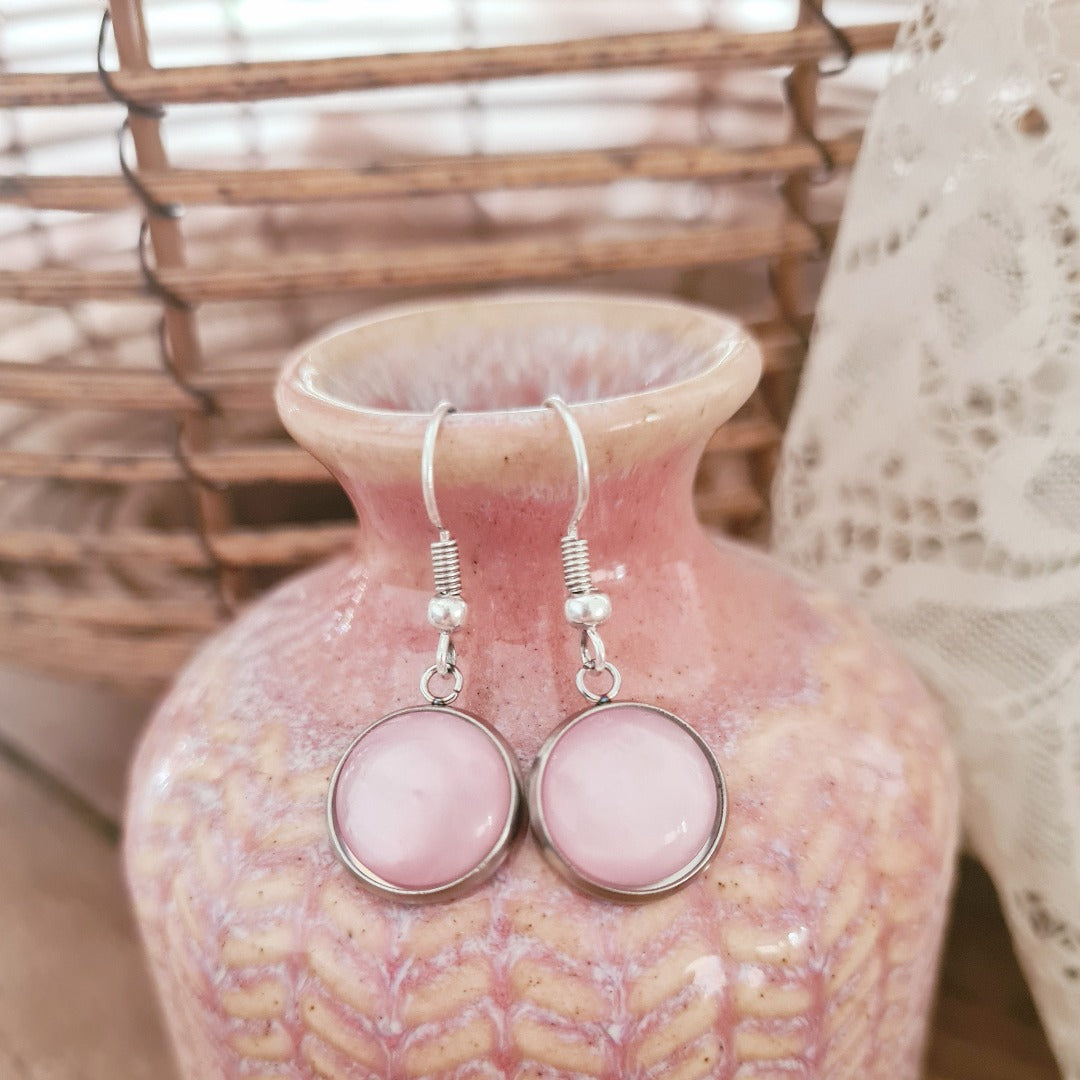Oorbellen met roze bedel in zilverkleurige setting op roze vaas productfoto